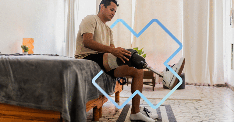 Un homme assis sur le bord de son lit ajuste sa prothèse de jambe. La scène se déroule dans une chambre lumineuse et paisible.