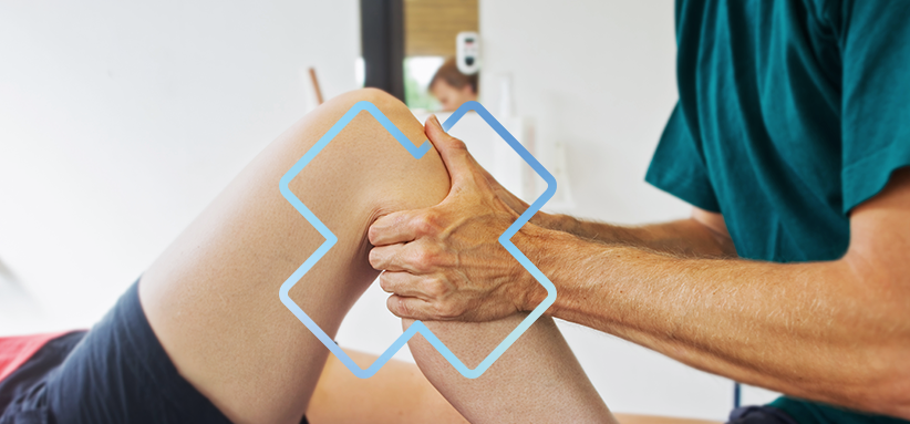 Thérapeute du sport effectuant une thérapie manuelle sur le genou d’un patient lors d’une séance de réadaptation.